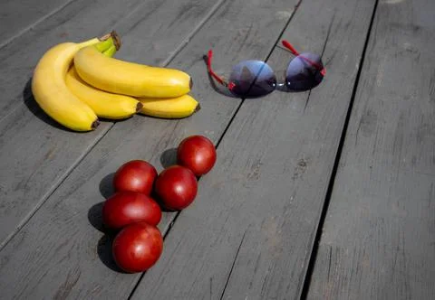 Mix composition with painted easter eggs, bunch of ripe bananas and sunglasses Stock Photos