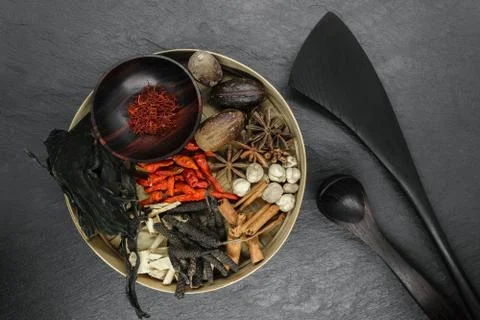 Mix composition of various exotic dried spices in natural bamboo bowl on blac Stock Photos