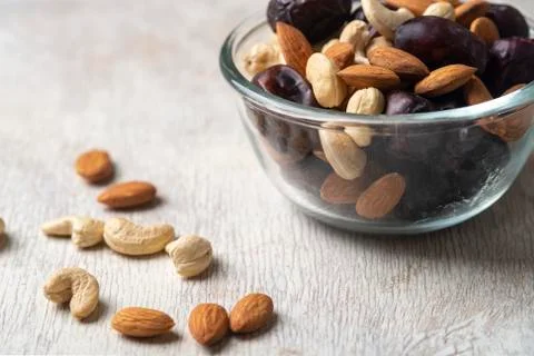 Mix of dates and nuts in plate on a white wood background .healthy food Stock Photos