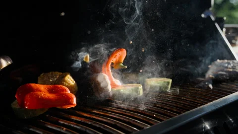 Mix of different fresh cut vegetables falling down on barbecue grill in super Stock Footage 143640187
