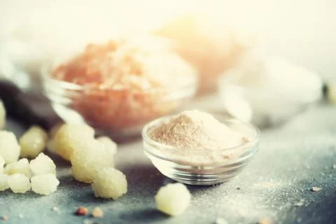 Mix of different salt types on grey concrete background. Sea salts, black and Stock Photos