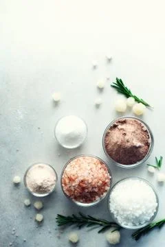 Mix of different salt types on grey concrete background. Sea salts, black and Stock Photos