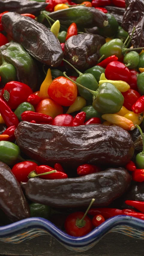 Mix of different types of chilies on a plate. Vertical video. Stock Footage 308254875