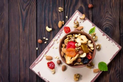 Mix of dried fruits and nuts on a wooden background. Stock Photos