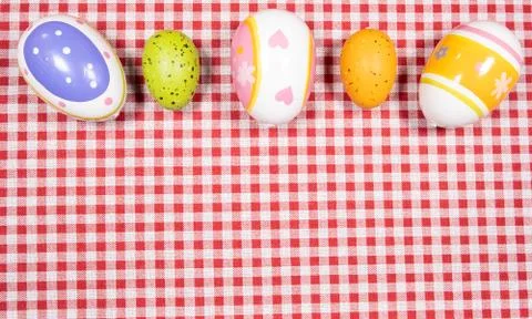 Mix of easter eggs of all colors and sizes on a background of red and white g Foto stock