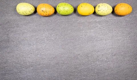 Mix of easter eggs of all colors and sizes on a gray granite stone background Stock Photos