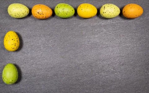 Mix of easter eggs of all colors and sizes on a gray granite stone background Stock Photos