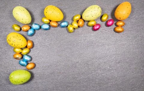 Mix of easter eggs of all colors and sizes on a gray granite stone background Stock Photos