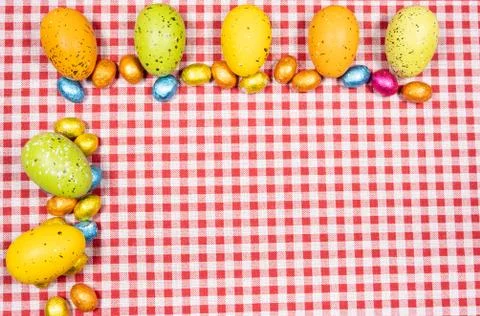 Mix of easter eggs of all colors and sizes on a background of red and white g Stock Photos