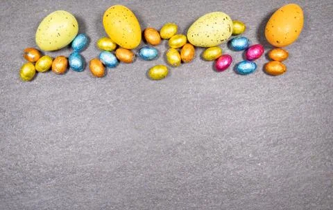 Mix of easter eggs of all colors and sizes on a gray granite stone background Foto stock