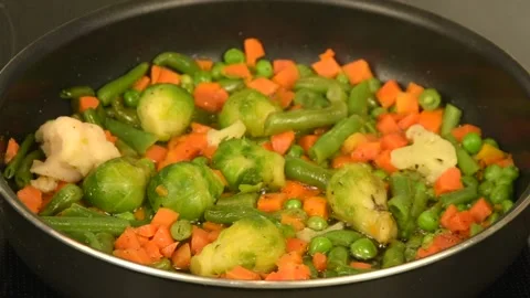 A mix of fresh vegetables is fried in a pan close-up. Vegan food. Healthy foo Stock Footage 131113457