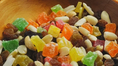 Mix of multi-colored dried fruits and nuts scattered on the surface, rotati.. 库存影片 270247206