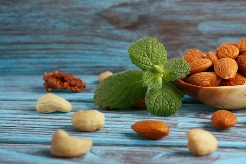 Mix of nuts and mint on a blue background 스톡 사진
