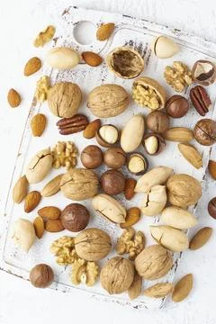 Mix of nuts - walnut, almonds, pecans, macadamia and knife for opening shell on Stock Photos