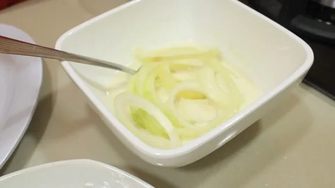 Mix the onions with the flour mixture. pour the chopped onions into the flou Stock Footage 334268438