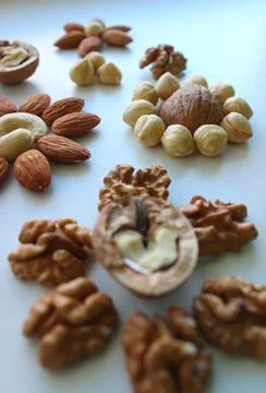 Mix Of Shelled Nuts In Flowers Pattern On White Surface Stock Photos