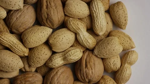 Mixed almonds walnuts and peanuts rotating on white background Stock Footage 328135792