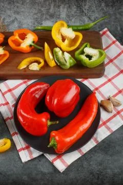 Mixed bell peppers on a white checked towel. Top view. Stock Photos