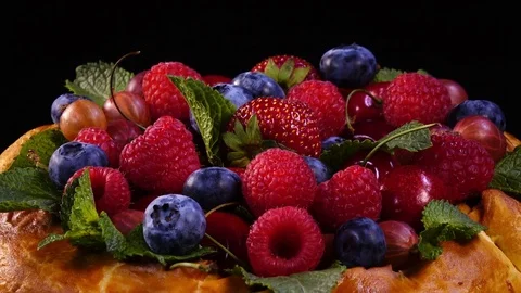 Mixed berries and mint leaves on homemade tasty pie. Close up rotation 4K 動画素材 77789403