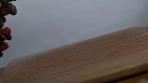 Mixed berries falling on chopping board in slow motion Stock Footage 100006900