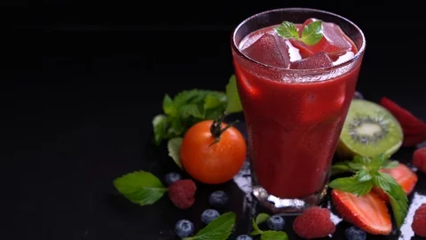 Mixed berry and beetroot juice with surrounding fruits on black background . Video stock 126514942