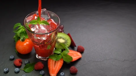 Mixed berry and beetroot pouring into tall glass with surrounding fruits . Stock Footage 126420286