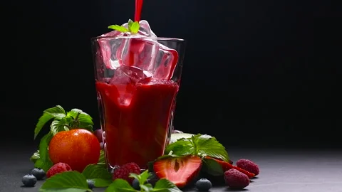 Mixed berry and beetroot pouring into tall glass with surrounding fruits Stock Footage 142514898