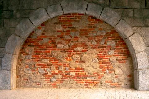 Mixed bricks and concrete. Arch made of concrete blocks and red bricks. Stock Photos