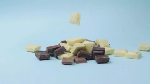 Mixed chocolate chunks drop onto pile in slow motion Stock Footage 166863267