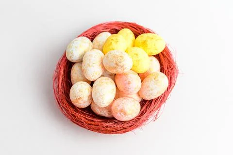 Mixed chocolate coated Easter eggs candies in a small red basket  Stock Photos
