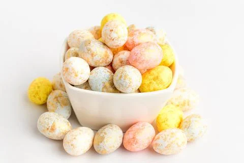 Mixed chocolate coated Easter eggs candies on a bowl isolated on a white table Stock Photos
