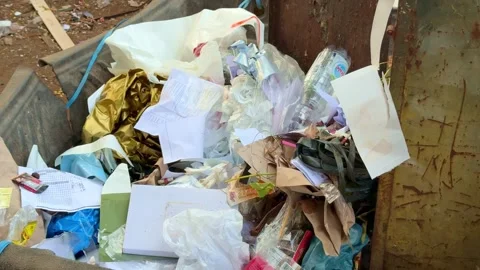 Mixed domestic trash in bin including plastic wrappers and paper waste. Stock Footage 342041196