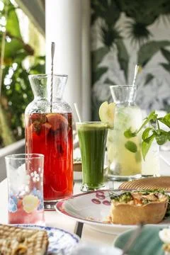 Mixed drinks on brunch restaurant table outdoors in singapore garden cafe r.. Stockfoto's