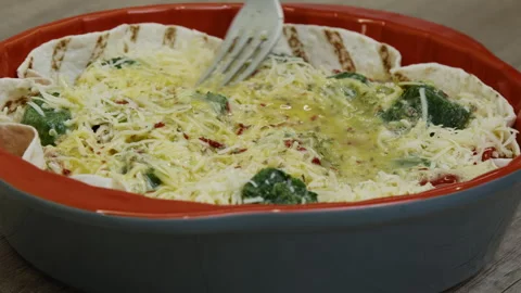 Mixed eggs over cheese, tomatoes and spinach in a baking dish. Stock Footage 266423089