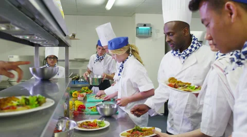 Mixed ethnicity team of professional chefs preparing food ready for service Stock Footage