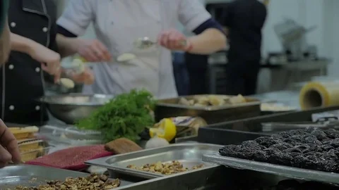 Mixed ethnicity team of professional chefs preparing and cooking food in a comme Stock Footage 72139888
