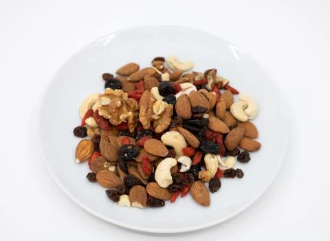 Mixed fruit and nuts on a white plate Stock Photos