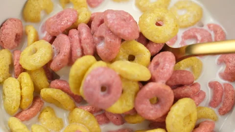 Mixed with golden spoon dry Breakfast cereal rings from in bowl Stock Footage 312681772