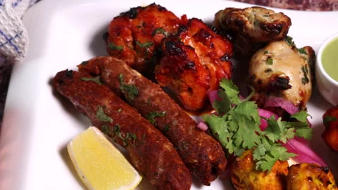 Mixed grill kebab chicken mutton beef prawn fish mint sauce lemon pickled onion  Stock Footage 150987950