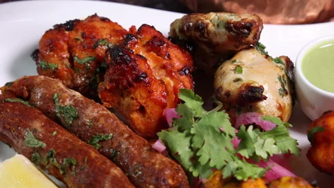 Mixed grill kebab chicken mutton beef prawn fish mint sauce lemon pickled onion  Stock Footage 150988125