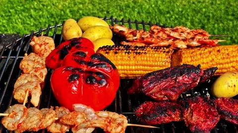 Mixed Grilled Meat, Vegetables, and Skewers Cooking on Outdoor Barbecue in Видео 336662004