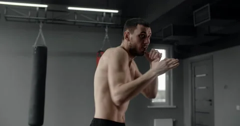 Mixed martial art fighter does shadow boxing to the camera, fighter man is Stock Footage 154041294