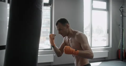 Mixed martial arts fighter kicks boxer bag in slow motion, fighter is training Stock Footage 158453067