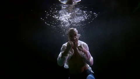 A mixed martial arts fighter practicing punches underwater in a pool Stock Footage 166834794