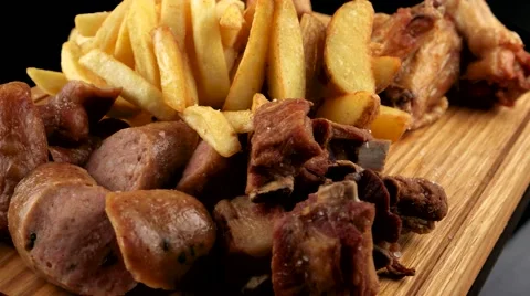 Mixed meat platter served with French fries and roasted potatoes Stock Footage 66482586