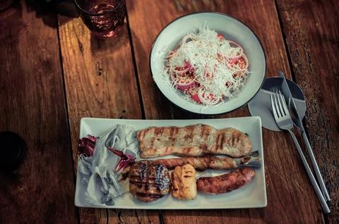 Mixed meat roasted with a side dish of Catania salad Stock Photos