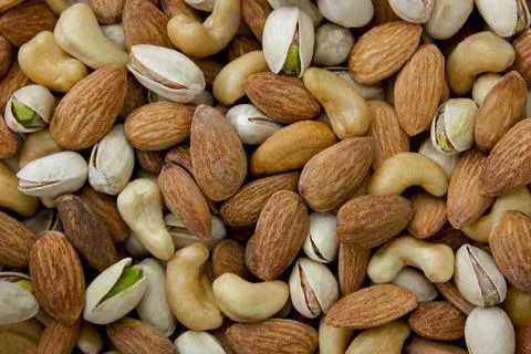 Mixed nut background. Cashews, almonds and pistachios. Stock Photos