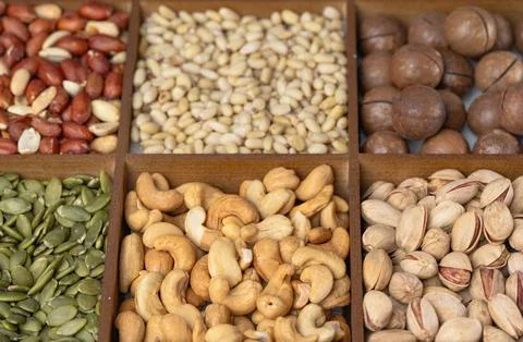 Mixed nut background: pine nuts, pistachios, cashews, almonds, hazelnuts, p.. Stock Photos