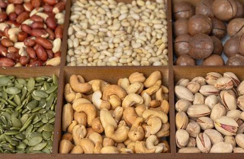 Mixed nut background: pine nuts, pistachios, cashews, almonds, hazelnuts, p.. Stock Photos