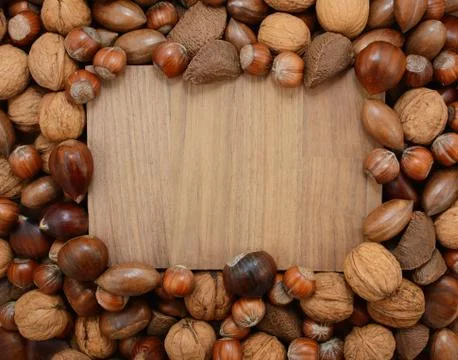 Mixed nuts frame a wooden background Stock Photos
